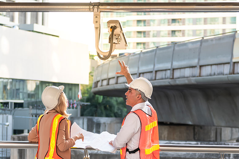 male engineer pointing to the CCTV installation point for a female coworker
